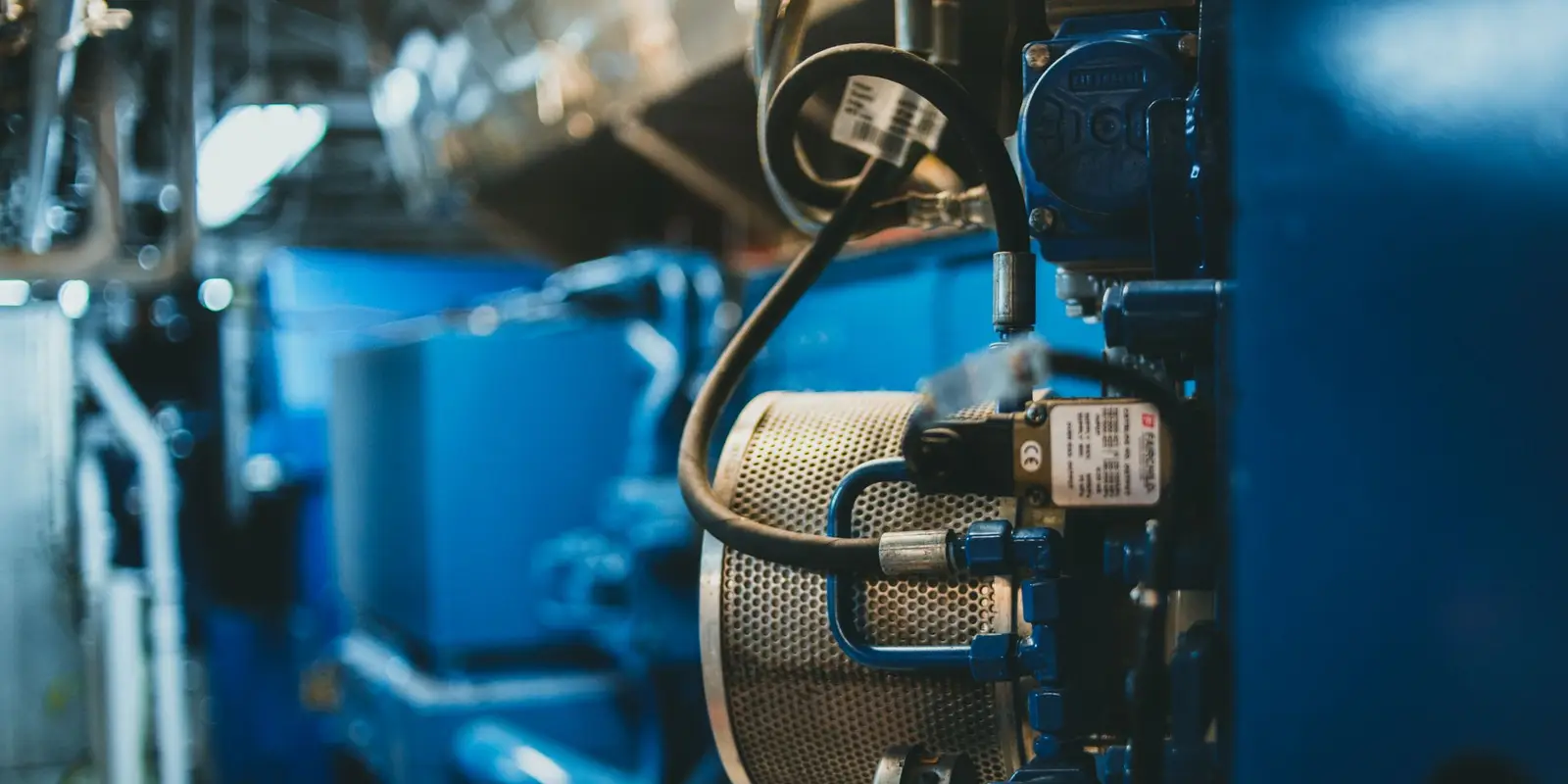 Close detail of blue industrial plant machinery with a strainer and instrumentation