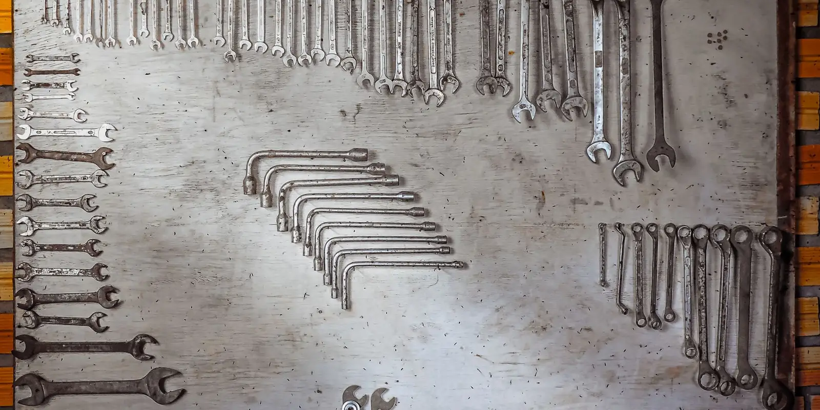 Spanners arranged by type and size on a workshop tool board