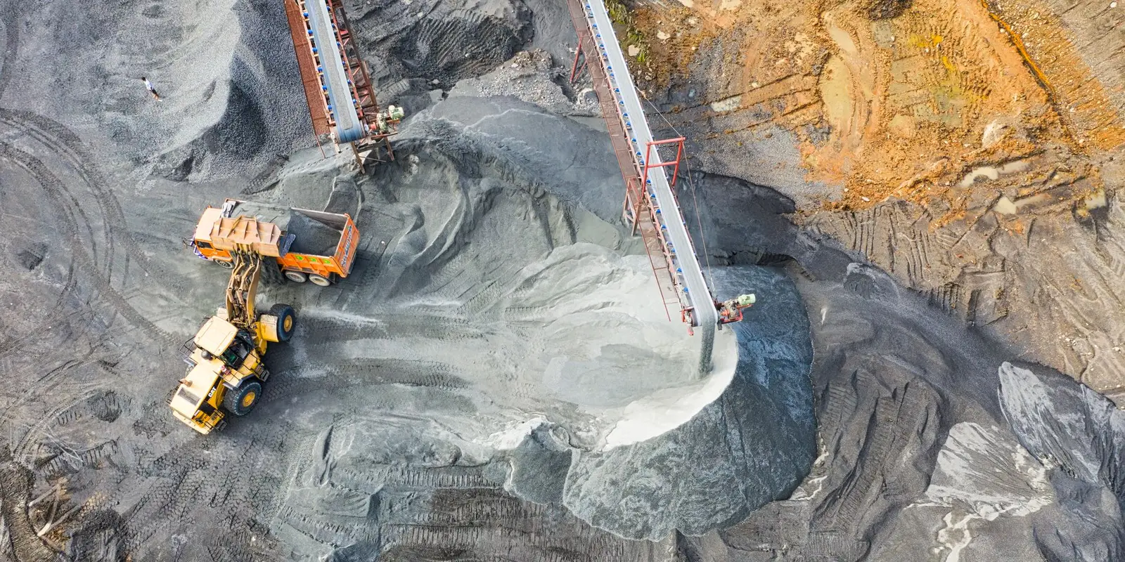 Conveyors discharging crushed rock onto stockpiles, seen from above