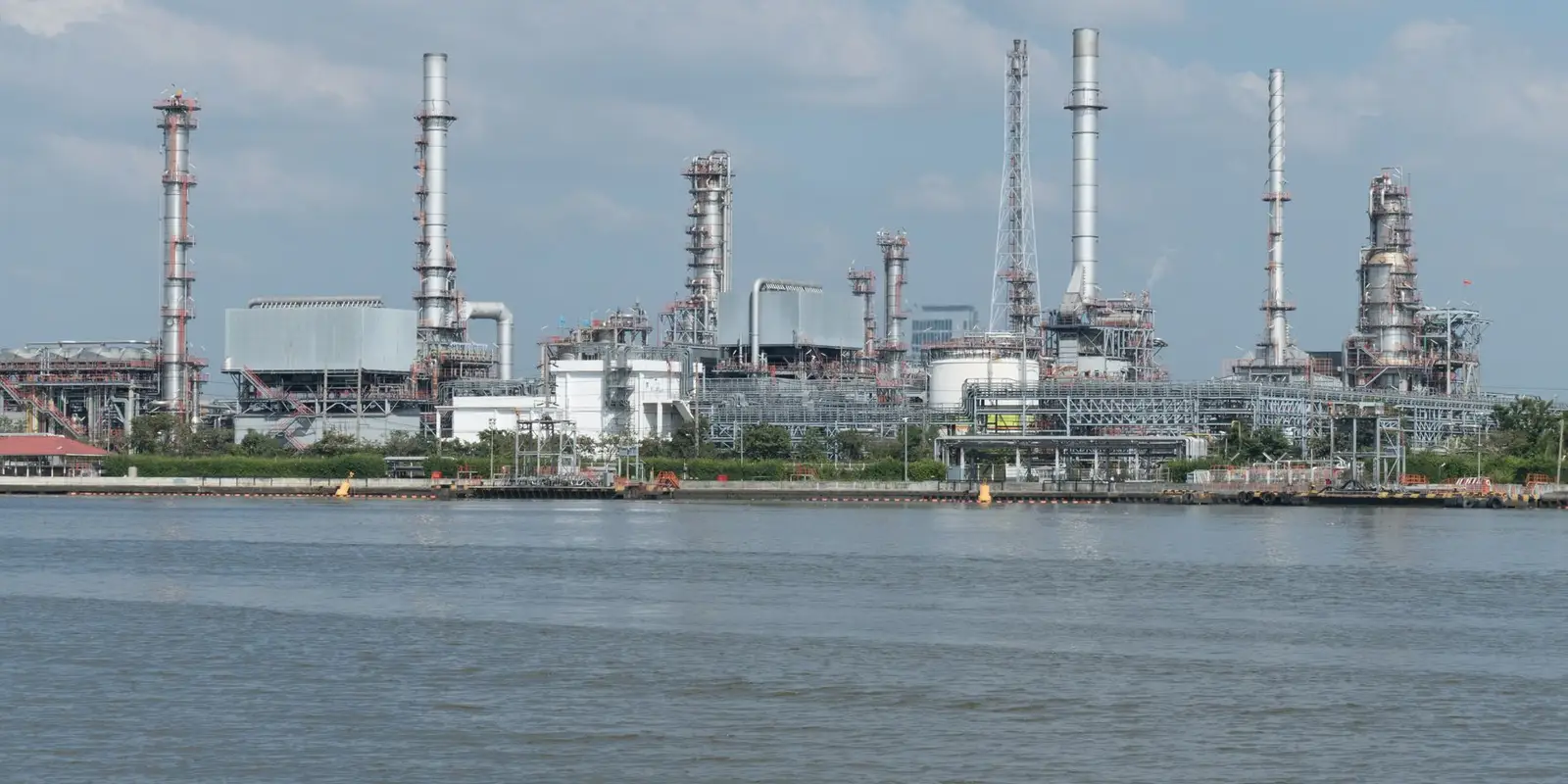 Processing plant with columns and stacks beside the water