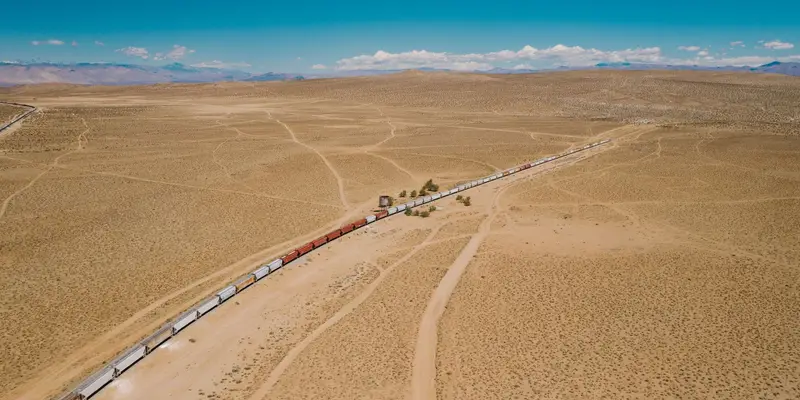 Loaded freight train on a rail corridor crossing arid country