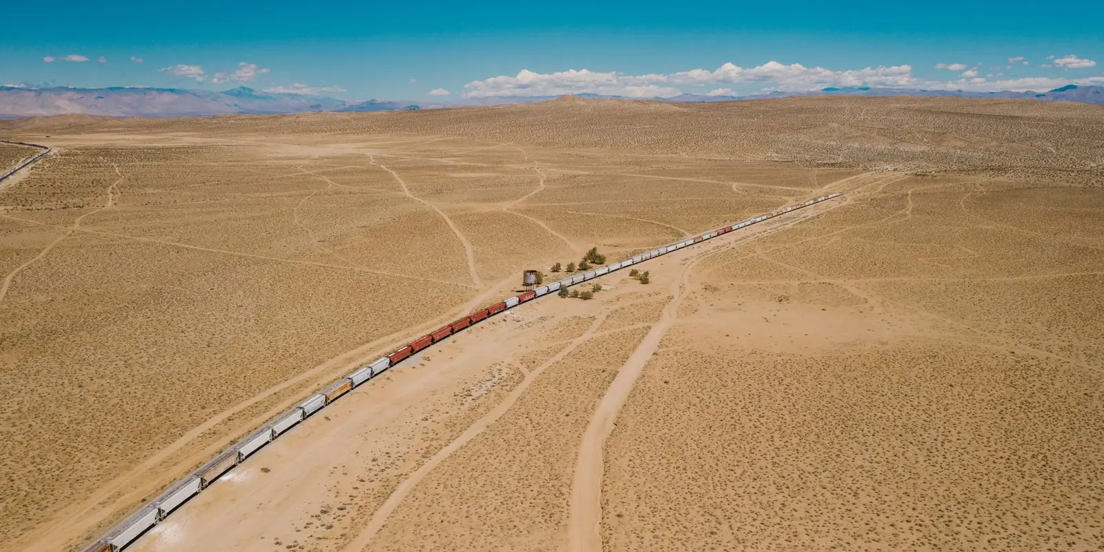 Loaded freight train on a rail corridor crossing arid country