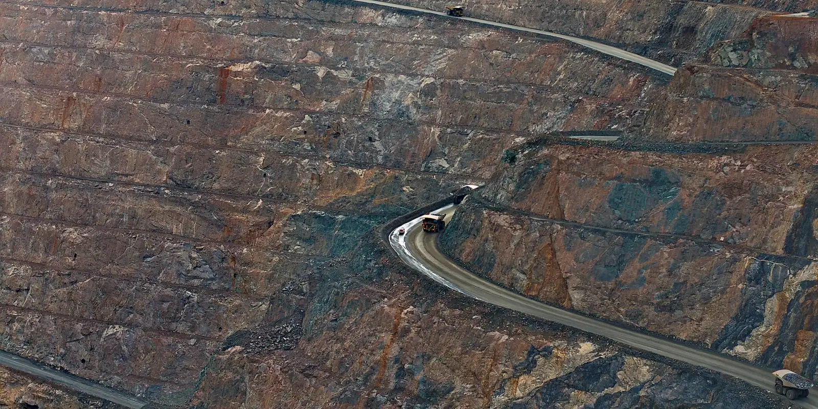 Haul truck working a benched open pit from above